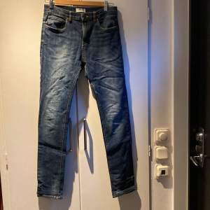 Säljer ett par snygga blå jeans från Lindex i modellen 'Detroit'. De är i slim fit och har en klassisk femficksdesign. Perfekta för både vardag och fest! 🕺