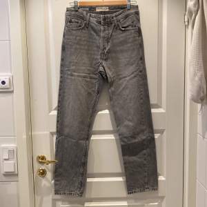 Säljer ett par grå jeans från Jack & Jones i loose fit, modell Chris. De har en klassisk femficksdesign och är i mycket bra skick. Perfekta för en avslappnad stil och passar till både vardag och fest. Dragkedja och knapp framtill.