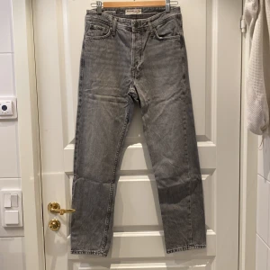Grå jeans från Jack & Jones modell Chris - Säljer ett par grå jeans från Jack & Jones i loose fit, modell Chris. De har en klassisk femficksdesign och är i mycket bra skick. Perfekta för en avslappnad stil och passar till både vardag och fest. Dragkedja och knapp framtill.