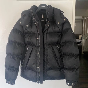 Hugo Boss Vinterjacka Svart Herr OANVÄND - Helt oanvänd Hugo Boss Vinterjacka Svart. Bara testad, säljer p.ga att den var för liten och jag inte kunde returnera den.  Extremt varm, skön och riktigt snyggt material. Kan diskutera priset. Skick: 10/10 Originalpris: 5795:-