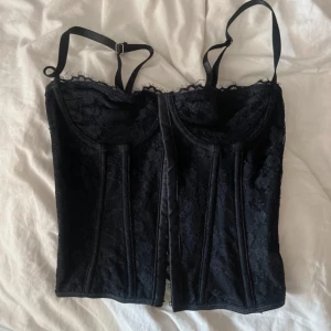 Svart korsett med spetsdetaljer - Snygg svart korsett med spetsdetaljer och justerbara axelband.