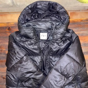 Svart pufferjacka från Zara - Säljer en snygg trendig svart pufferjacka från Zara. Trendigt material och sitter jättefint, säljer för jag har fått en ny jacka. Går att förhandla pris ❣️