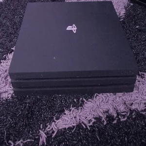 Svart spelkonsol från Sony - Säljer en svart spelkonsol från Sony, troligen en PlayStation-modell. Den har en stilren design med flera portar på baksidan för HDMI, USB och nätverksanslutning. Perfekt för gamingkvällar eller som en del av din hemmabio. Konsolen kan behöva städas inuti från all damm som byggs upp, och har ingen kontroll med den så jag säljer lägre än vanligt. Hdmi kablar förmodligen kan skickas med.