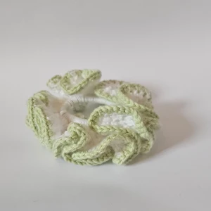 Handgjord virkad scrunchie i grönt och vitt - Superfin handgjord scrunchie som är virkad i en härlig kombination av grönt och vitt. Perfekt för att ge din frisyr en söt och unik touch. Den är elastisk och passar de flesta hårtyper. Perfekt accessoar för både vardag och fest!