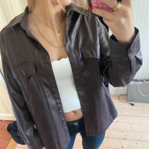 Skytsnygg brun skinnjacka - Jättesnygg mörkbrun skinnjacka från Bershka. Perfekt höstjacka🤩 storlek 34, vilket jag har vanligtvis men tror att den även hade passat en 36a🤩