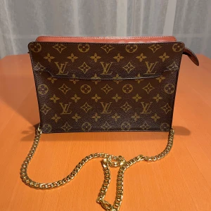 Louis Vuitton Pochette axelremsväska monogram - Skick: 4/5. Har fler detaljerade bilder som jag kan skicka! Får endast plats med fem här. Har en utförlig beskrivning också som inte får plats på annonsen som jag gärna kan skicka. Bevis på att den är äkta finns. Datumkod: 872MI. Butikpris: 13 000kr
