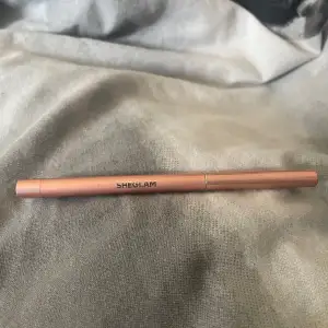 Säljer en Sheglam Fairy Wand Precision Highlighter Pencil i en snygg roséguld nyans. Perfekt för att ge ditt ansikte en subtil glöd och highlighta dina bästa drag. Pennan är smidig att använda och lätt att ta med i väskan. Perfekt för både vardag och fest!