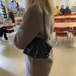 Svart axel väska - Säljer denna väska liknande den från Jackie! Man kan ta bort banden och byta ut så man kan ha den sidled🖤 magneten är  trasig. Pris kan diskuteras 