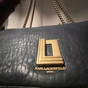 Karl Lagerfeld väska - Jätte fin axelremsväska från Karl Lagerfeld. Mörkblå med guldiga detaljer! Köpt in NY ny för 2 år sedan,  köptes för 3000kr. Bra skick men lite små repor, inget man tänker på. Hör av er om ni vill ha mer bilder💕💞💗
