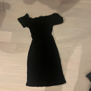 Svart tight fest  klänning med korta ärmar - Elegant svart klänning med korta ärmar och en tight passform. Klänningen har en klassisk design som passar till många tillfällen.