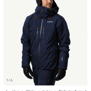 Mörkblå jacka från EQPE - Storlek S men passar även  en M.  Säljer en mörkblå jacka från EQPE med huva och flera praktiska fickor. Jackan har dragkedjor i orange detaljer och är perfekt för kyliga dagar. Den är långärmad och har en stilren design. Använd 1 vecka i skidbacken, som ny.