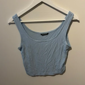 Ljusblå ribbad linnetopp från Shein - Säljer en ljusblå ribbad linnetopp från Shein. Toppen har breda axelband och en rundad halsringning. Perfekt för varma dagar eller som ett lager under en jacka.