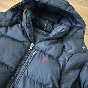 Collection Navy dunjacka från Polo Ralph Lauren - Säljer en Navy blue dunjacka från Polo Ralph Lauren. Skick 10/10 har haft den i en månad Inget fel med den nytt pris är 5799kr. Pris kan diskuteras. vid intresse de är bara och skriva🍾🍾