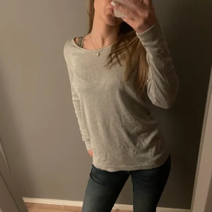 Grå långärmad tröja - Säljer en grå långärmad tunnstickad tröja med urringning. Tröjan har en mjuk och bekväm passform.🩶