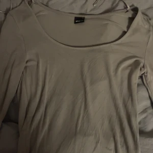 Grön långärmad topp från Gina Tricot - Säljer en stilren grön långärmad topp från Gina Tricot. Perfekt för en enkel och avslappnad look. Toppen har en rund halsringning och är tillverkad i ett mjukt material.