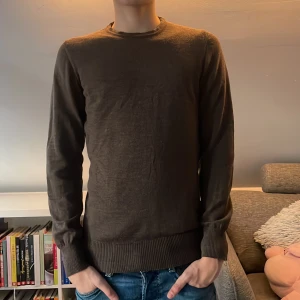 Brun merinoull tröja - Säljer en stilren brun merinoull tröja från Riley med rund hals och långa ärmar. Tröjan har ribbade muddar vid ärmslut och nederkant, vilket ger en snygg passform. Perfekt för en avslappnad look. Personen på bilden är 170 och hör av er vid frågor och funderingar! Priset ej hugget i sten!