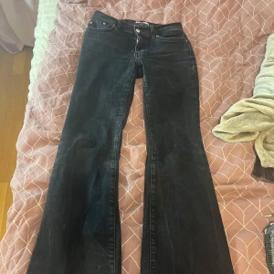 Svarta bootcut jeans - Snygga svarta bootcut jeans med klassisk femficksdesign och knappgylf. Perfekta för en stilren look. Nypris 499kr
