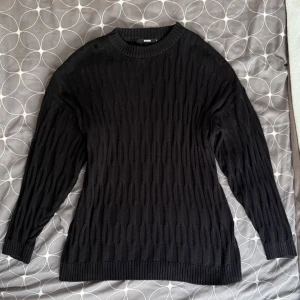 Svart stickad tröja - Säljer en svart stickad tröja med ett diskret mönster. Tröjan har långa ärmar och en bekväm (lite oversized) passform. Strlk S men passar M Org pris 400kr