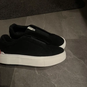 Svarta sneakers med vit sula - Snygga svarta sneakers med en tjock vit sula. Knappt använda och säljs ej längre. 