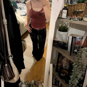 Vinröd ribbad linnetopp med spetsdetaljer - Snygg vinröd linnetopp med smala axelband och vacker spetsdetalj vid halsringningen och nederkanten. Toppen har en ribbad struktur som ger en stilren look. Skriv vid frågor💗