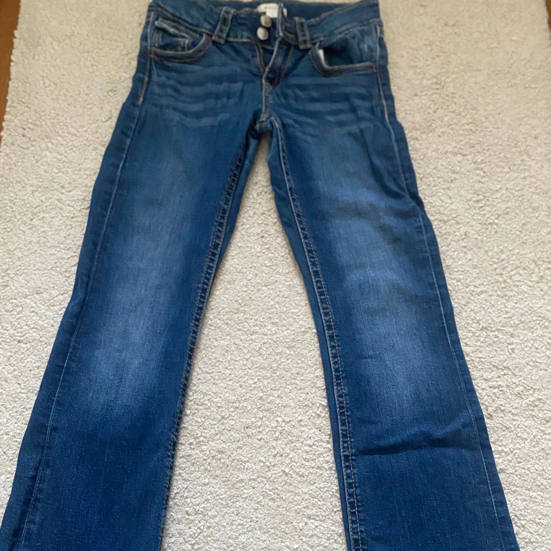 Blå lågmidjade bootcut jeans från Gina Tricot