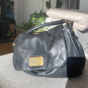 Svart skinnväska från Marc Jacobs - Snygg svart skinnväska från Marc Jacobs med guldfärgade detaljer och en praktisk dragkedja.  Pris kan diskuteras ❣️