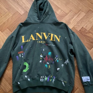Grön hoodie från Lanvin - Säljer en grön hoodie från Lanvin som är i collab med gallery dept. As skön passform och väldigt sällsynt i sjukt bra skick