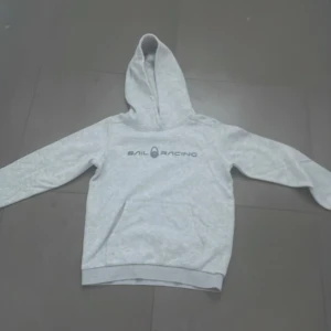  Sail Racing Hoodie - Säljer en stilren grå hoodie från Sail Racing. Tröjan har en klassisk design med lång ärm och en bekväm huva. Perfekt för en avslappnad look. 🩶