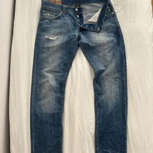 Blå jeans med slitningar från DonDup -  Säljer ett par sjukt snygga jeans från  DonDup Med fina detaljer och slitningarjeansen är använda men jag är i bra skick de är köpta i Italien. Storlek är 31-34