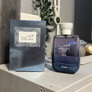 Hawas Ice Eau de Parfum - Säljer en elegant flaska av Hawas Ice Eau de Parfum för herrar. Flaskan har en stilren design i blått glas med en vit kork. Doften är fräsch och modern, perfekt för den som vill sticka ut. Kommer i en snygg förpackning som matchar flaskans design. Bara testsprayad. 100ml
