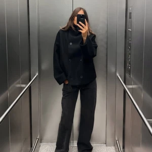 Svart kappa med dubbelknäppning - Snygg svart kappa med dubbelknäppning och bred krage. Använd fåtal gånger, så den är i mycket fint skick. Nypris 999kr 