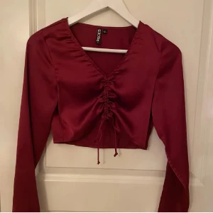 Vinröd topp  - Snygg vinröd topp från new yoker med långa ärmar och v-ringning. Toppen har en stilren design med snörning framtill som ger en fin detalj. Perfekt för att lyfta din outfit! I ett fint skick ⭐️