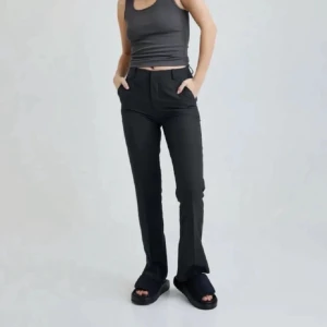 Svarta kostymbyxor - Snygga svarta kostymbyxor med en klassisk bootcut-stil. Perfekta för en stilren look. Byxorna har en hög midja och är tillverkade i ett bekvämt material som ger en elegant passform.