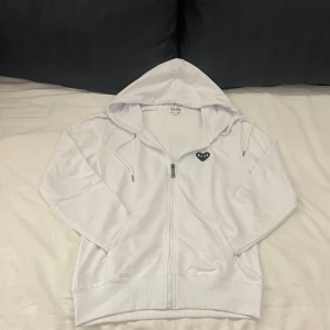 Vit Cdg Zip-Hoodie - En riktig snygg Zip-hoodie från Comme des Garçons. | Skicket är 10/10. Men det tål att nämnas att den relativt tunn men funkar fortfarande bra som ett extra lager för att hålla värmen. | Det är bara att höra av sig om man har några frågor eller vill ha flera bilder🎉🎉🎉