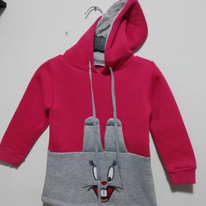 Rosa och grå hoodie med kaninmotiv - Säljer en söt rosa och grå hoodie med ett kaninmotiv framtill. Hoodien har långa ärmar och en praktisk huva. Perfekt för en avslappnad stil.