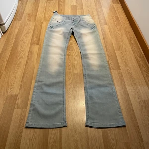 Lågmidjade bootcut jeans  - (19) De perfekta ljusblåa lågmidjade bootcut jeansen med massa stretch k och fixa brodyr detaljer, helt ny med lappar kvar. Midjemått rakt över:34 cm, innerbenslängd: 86cm💖