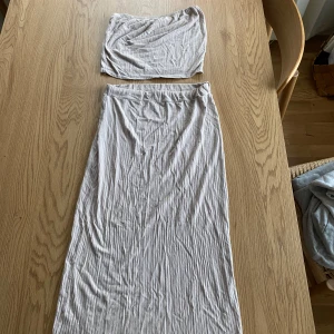 Beige set med tubtopp och långkjol - Snyggt beige set med en tubtopp och matchande långkjol. Perfekt på sommaren under varma dagar, har såklart klippt bort lapparna på båda delarna, men den är inköpt från Missäy under 2020 och är storlek S, men väldigt stretchigt material som även passar strl M!
