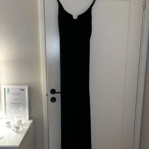 Svart lång kläning med slits - S, använd en gång på nyårsafton!  V ringning med bygel upptill!