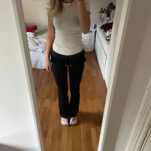 Juicy Couture - Jag säljer ett par mörkblåa Juicy byxor i storlek S. Jag är 174cm, och de passar bra i längden. De är stretchiga och går att spänna åt. De är använda några gånger, men inga skador på byxorna. 