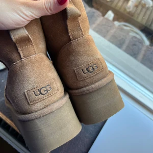 Äkta UGGs storlek 40 - Säljer ett par klassiska UGG boots i mjuk mocka med varm och fluffig insida. Perfekta för kalla vinterdagar. De är i mycket bra skick, varsamt använda men lite slitna under vid sulan då stenar har fastnat samt lite smutsiga på plattå sulan på sidorna. Modellen är ”Classic mini platform” i färgen chestnut 🤎  Nypris: 2295kr 🤎 Mitt pris: 1650kr, ett riktigt kap och perfekt till vintern och hösten😍  Priset är diskuterbart vid snabb affär ☺️