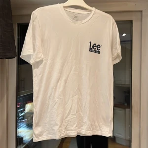 Vit t-shirt från Lee - Säljer en klassisk vit t-shirt från Lee i storlek M. Den har en enkel design med Lee-loggan tryckt på bröstet. Perfekt för en avslappnad stil och passar till det mesta. T-shirten är i bomull och har en normal passform. Perfekt för vardagsbruk!