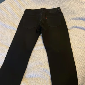 Svarta jeans från Levi's - Säljer ett par svarta jeans från Levi's i mycket bra skick. De har en klassisk design med fem fickor och en bekväm passform. Perfekta för både vardag och fest! 🖤