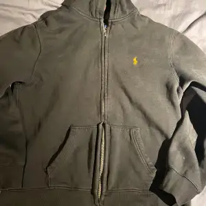 Säljer en svart zip hoodie från Polo Ralph Lauren.tröjan har änvänds en del och har ett litet hål vid ena fickan 