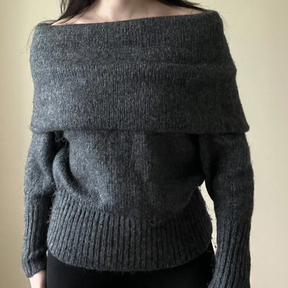 Säljer en superfin mörkgrå stickad tröja med offshoulder-design. Perfekt för kyliga dagar med sin mysiga och stilrena look. Tröjan har långa ärmar och ribbade detaljer vid ärmslut och nederkant. Passar både till vardags och lite finare tillfällen. 🖤. Tröjor & Koftor.