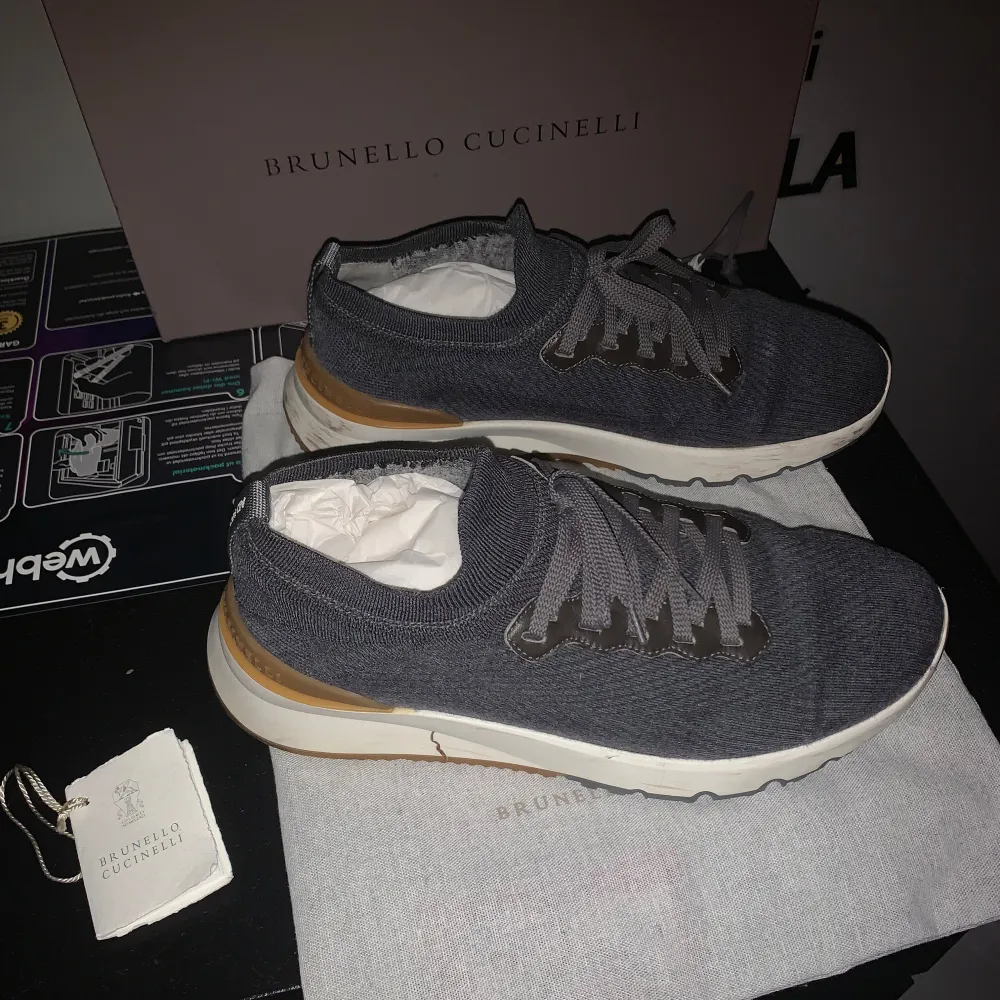 Säljer ett par snygga grå sneakers från Brunello Cucinelli i mycket bra skick. De har en stilren design med snörning och en bekväm sula. Perfekta för både vardag och festliga tillfällen. Kommer med originalförpackning och dustbag. Litet hål se sista bild.. Skor.