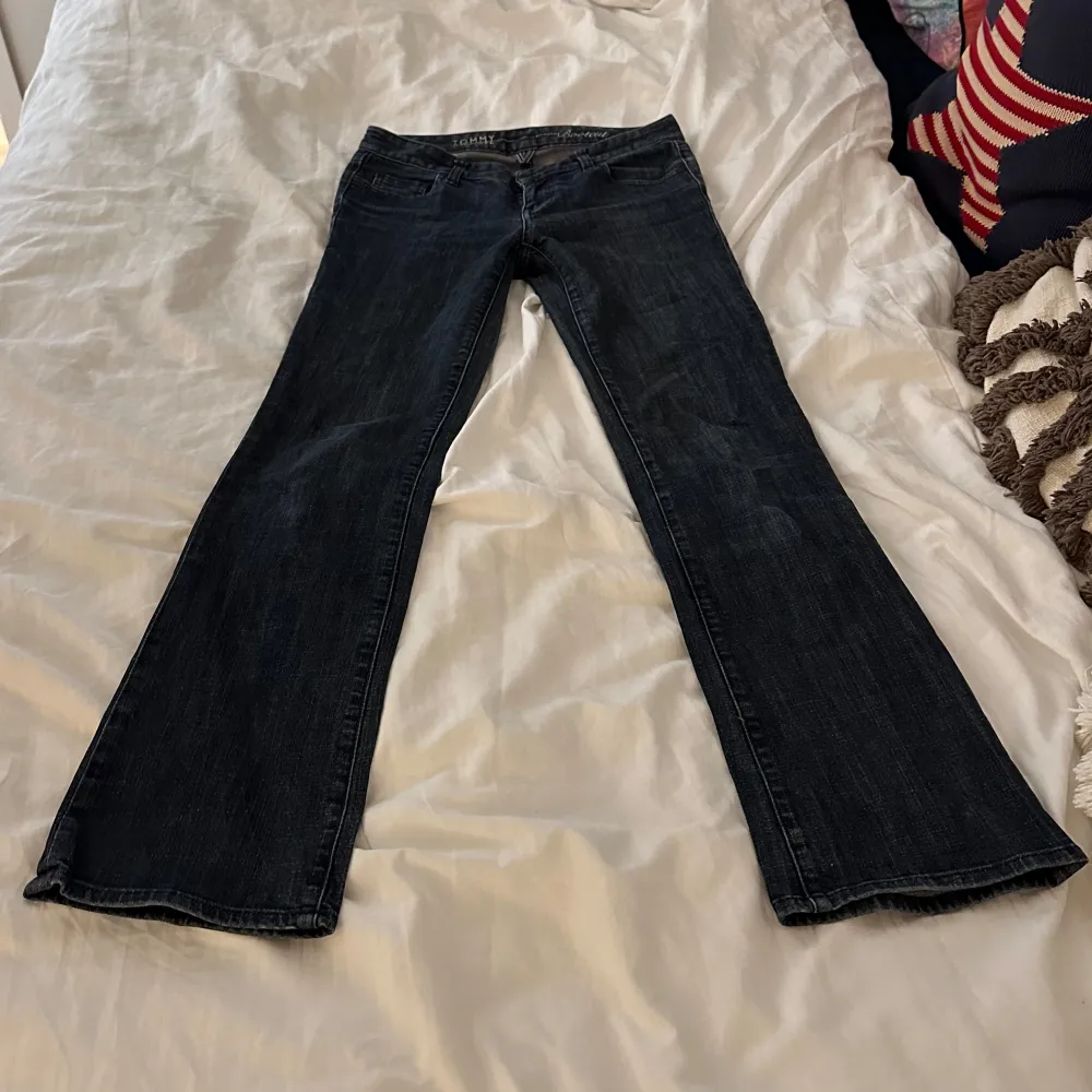 Säljer ett par mörkblå jeans i bra skick. De har en bootcut-stil och är lågmidjade. Baktill finns snygga fickor med knappar som ger en extra touch. Perfekta för både vardag och fest! Midja: 36cm o innerben: 80cm . Jeans & Byxor.