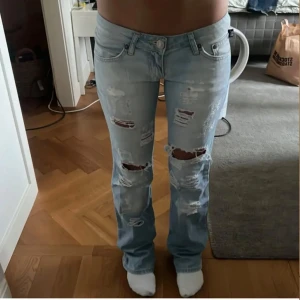 Victoria Beckham jeans - Säljer ett par ljusblå jeans från Victoria Beckham med coola slitningar och snygga detaljer på bakfickorna. Säljer då dem är lite för små för mig! Köpta här på plick, säljer billigt pågrund av att dem är rätt så slitna och hsr blandannat håll som vissas på bild 3. Men kommer absolut kunna användas om dem sys igen! Tidigare ägare har även sytt fast lappar på vissa håll så dem inte syns! Har ej använt eftersom dem var försmå
