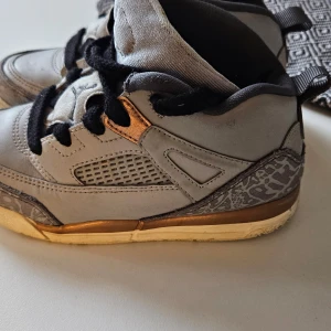 Baby Air Jordan ,storlek EU21 - Säljer ett par gråa Nike Air Jordans i bra skick. Skorna har ett coolt mönster på sidorna och en gyllene detalj vid sulan. De har svarta snören och en tydlig Jordan-logga på tungan. Perfekta för både vardag och sportiga aktiviteter.