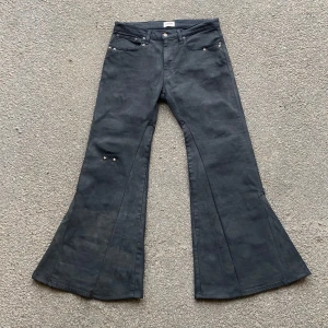 Wax-Painted Flare Jeans - Målade med en speciellt färg för att göra dem ”vaxade”. Flare passform, med distressing och nitar. Storlek 34/32 Midja: 42cm Längd: 106cm Benöppning: 39cm