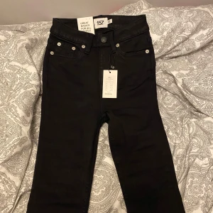 Svarta jeans från 157 - Säljer ett par svarta jeans från 157 i storlek XXS. De har en snygg flare-stil och är i kort längd. Perfekta för en stilren look, oavsett om det är vardag eller fest. Helt nya med taggar kvar!